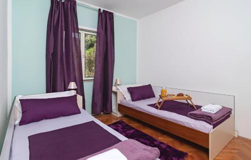 卡什泰拉Villa Olive Tree的紫色窗帘间内的两张床