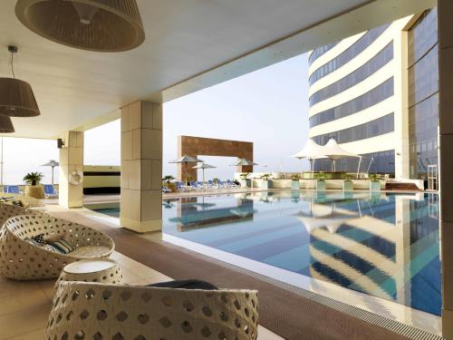科威特Symphony Style Hotel Kuwait的酒店游泳池享有大楼的景色