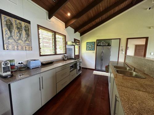 萨武萨武Latui Lodge的一间大厨房,配有白色的橱柜和水槽