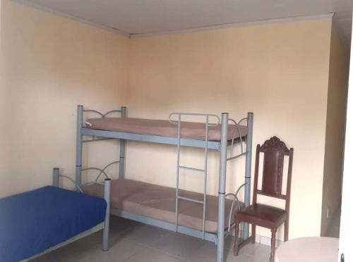 曼加拉蒂巴Apartamento em Muriqui/RJ - apt 203的带两张双层床和椅子的房间