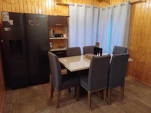 科克拉内Cabaña ñandú的厨房配有桌椅和冰箱。