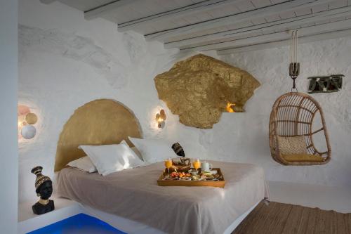 卡拉沃斯塔西Onar Suites & Villas的一间卧室配有一张床,上面放着一个食物托盘