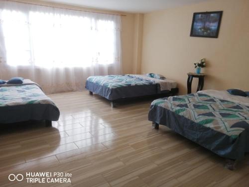 巴尼奥斯CASA DE LINDA的一间卧室设有两张床和窗户。