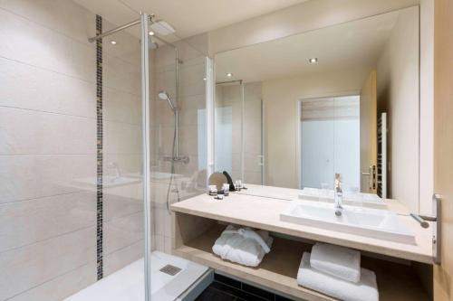 桑利斯Best Western Plus Hôtel Escapade Senlis的一间带水槽和淋浴的浴室