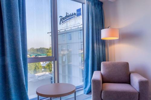 加里宁格勒加里宁格勒丽笙酒店的客厅配有椅子和大窗户