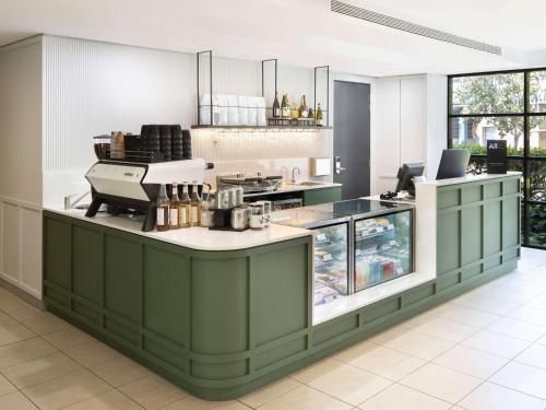 悉尼Mercure Sydney Macquarie Park的厨房配有绿色橱柜和台面