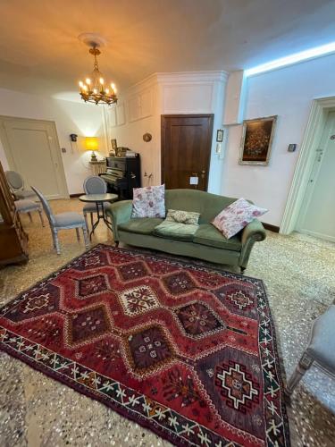 威尼斯Lions Venice Guest house的客厅配有绿色沙发和红色地毯。