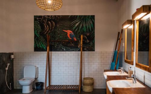 尼拉瓦利C Beyond Nilaveli的浴室设有两个水槽,墙上挂有绘画作品