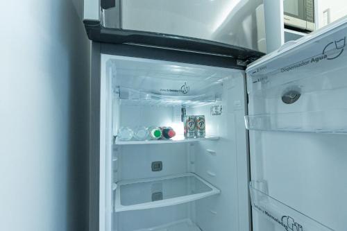 圣地亚哥洛斯卡巴Soha Suites Santiago Gem Rare Find的厨房里设有白色冰箱,门开