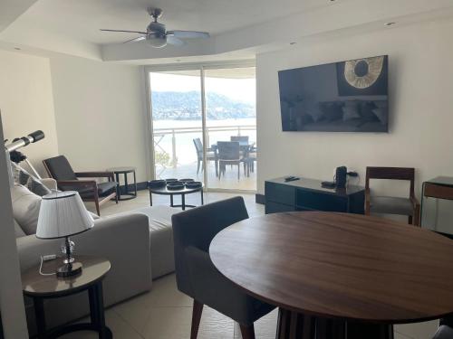 伊斯塔帕Bay View Grand Marina Ixtapa condo en pie de playa的客厅配有沙发和桌子