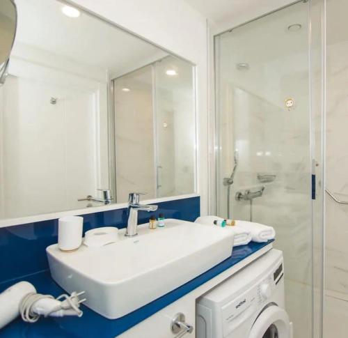 巴统Queen apartments in batumi的浴室配有白色水槽和淋浴。