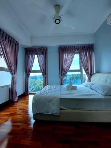 莎阿南Suria Homes的一间卧室配有一张大床和紫色窗帘