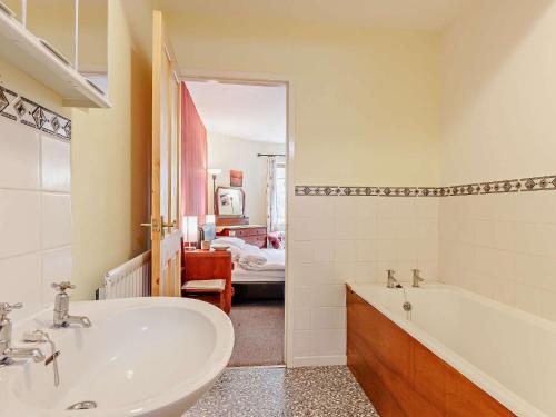 Cemmaes3 Bed in Machynlleth 93080的一间带水槽和浴缸的浴室以及一张床
