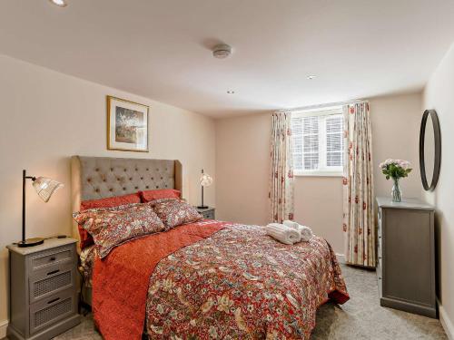 Wilsden1 Bed in Bingley 91492的一间卧室配有一张带红色棉被的床和窗户。