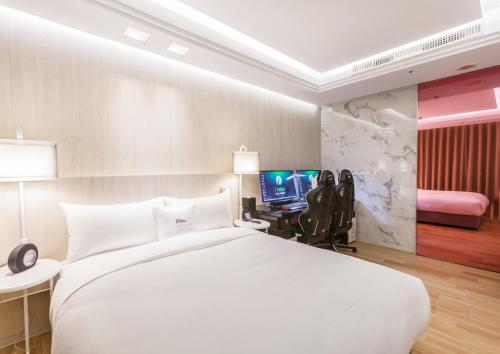 桃园市i hotel 桃园馆的卧室配有一张白色大床和电视。
