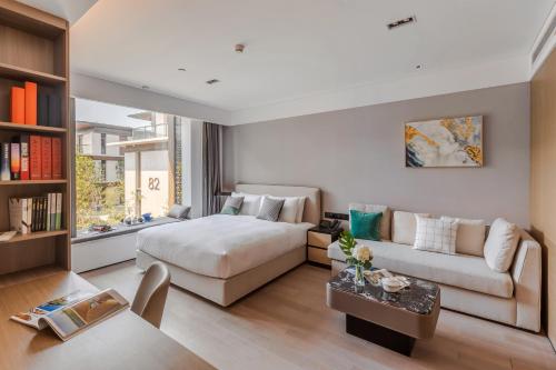 苏州苏州新区科技城壹棠服务公寓的客厅配有床和沙发
