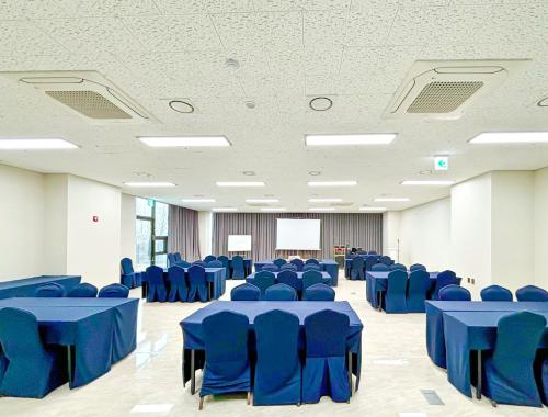 仁川市Airsky Hotel Incheon的大房间设有蓝色的桌椅