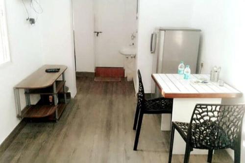 班加罗尔Clover Suites - Studios at Koramangala 4th block的厨房配有桌椅和冰箱。