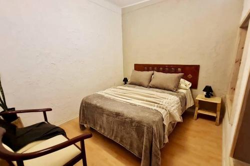 维库尼亚Espacio Borde Rio, Casa Pisqu的一间卧室配有一张床和一把椅子