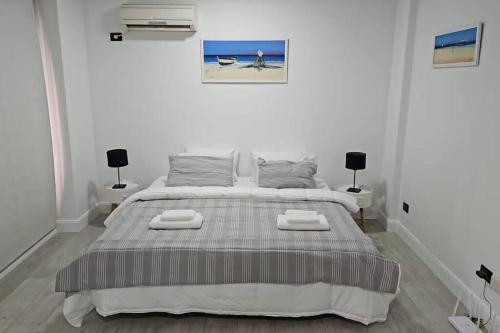 布宜诺斯艾利斯Hermoso apartamento en el corazón de Palermo - Cerca de todo的白色卧室配有一张带两盏灯的大床