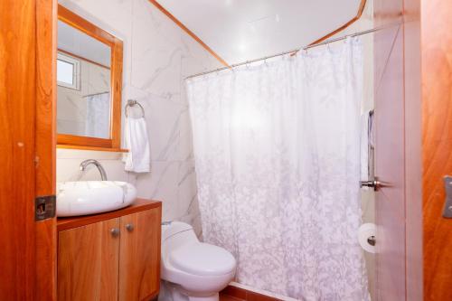 阿约拉港EXCLUSIVE CONDO GALAPAGOS and BEYOND 1的带淋浴、卫生间和盥洗盆的浴室