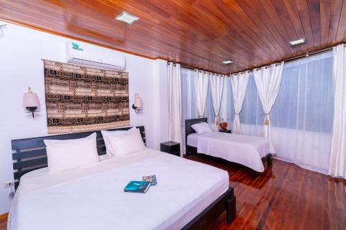 阿约拉港EXCLUSIVE CONDO GALAPAGOS and BEYOND 1的一间卧室设有两张床和木制天花板