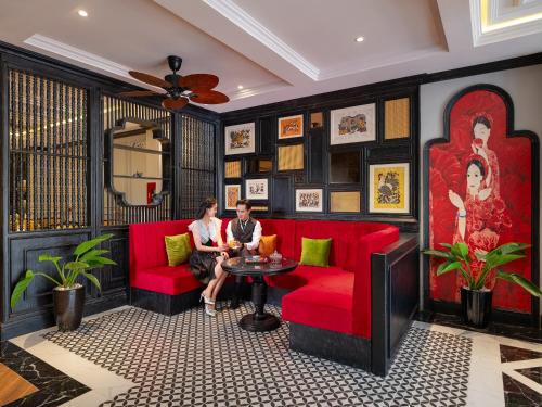 顺化色调宁静皇宫酒店的两人坐在一个房间里红色的沙发上