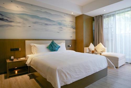 广州Paco Hotel Tiyuxilu Metro Guangzhou-Close to subway entrance的卧室设有一张白色大床和一扇窗户。