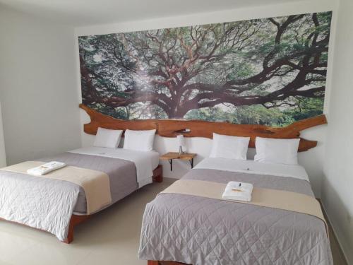 HuamboCasaBlanca Hotel的墙上画画的房间里设有两张床