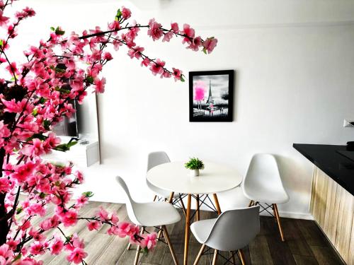危地马拉Bertiz Cozy的一间设有桌子的用餐室和一棵带粉红色花卉的树