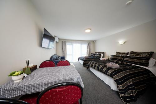 凯库拉柳岸汽车旅馆的一间带四张床和椅子以及电视的房间