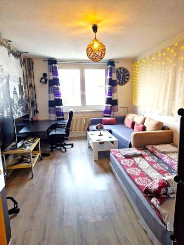 柏林Cozy trendy spacious room in green area 12 min. near to the center Alexanderplatz的带沙发和书桌的客厅