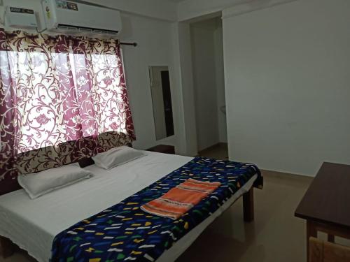布莱尔港Punjab Residency的一间卧室配有一张带窗帘的床和窗户