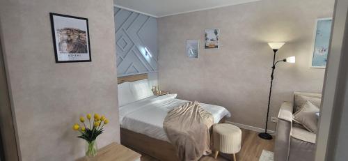 乌斯季卡缅诺戈尔斯克Lux Home Astana的一间卧室配有床、灯和鲜花