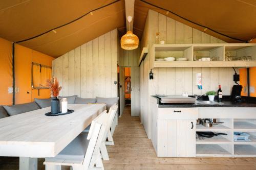 索尔陶Glampingzelt Family - Lodge的厨房以及带桌椅的用餐室。