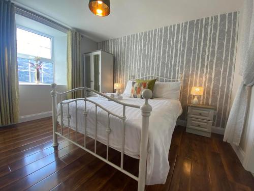 DerryleaCeim house, Restful rural home Gap of dunloe, Killarney的卧室配有白色的床和镜子