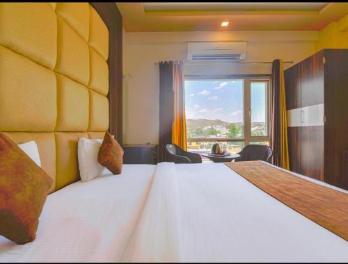 BedlaThe royal galaxy & Resort的一间卧室设有一张大床和大窗户