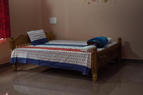 PonnampetCoorg Stream Side Homestay的一间卧室配有一张木床,床上有毯子