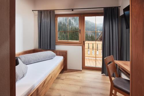 克里姆尔博尔海克全景酒店的一间卧室配有一张床、一张书桌和一个窗户。