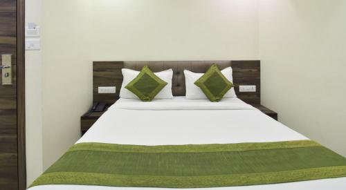 艾哈迈达巴德Hotel Palliate的卧室配有带绿色枕头的白色床