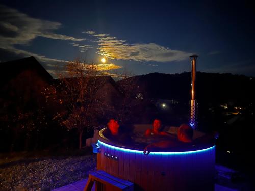 瓦马Bucovina Lodge Pension的三人在晚上坐在热水浴缸中