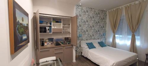 米兰马尔科纳24公寓式酒店的一间卧室配有一张床和一张带微波炉的书桌