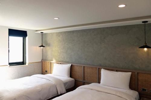 员林康桥商旅 - 员林馆 的配有白色床单的客房内的两张床