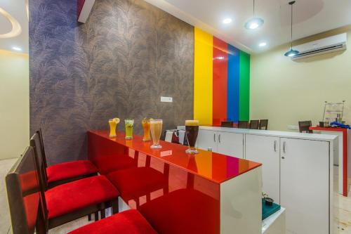 孟买Arton Regency的色彩缤纷的厨房,配有红色椅子和桌子