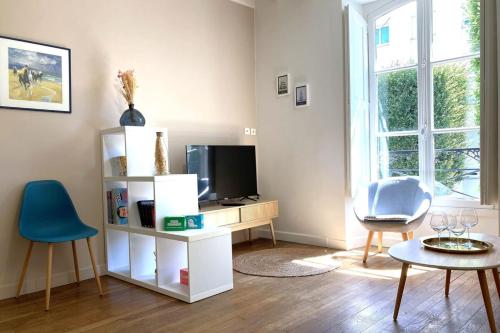 南特Le Mario-Cosy appart au calme proche centre的客厅配有电视和桌椅