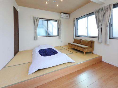 东京东京古都涩谷4公寓的一间卧室配有一张床、一张沙发和窗户。