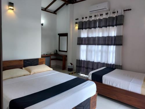 阿努拉德普勒Green Shield Resort的酒店客房设有两张床和电视。