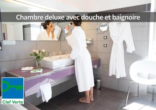 罗德兹HÔTEL LA FERME DE BOURRAN - écoresponsable parking gratuit的正在浴室刷牙的女人