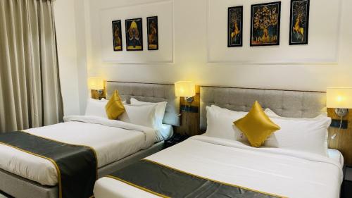 GodarpuraThe Shankara View的配有黄色枕头的酒店客房的两张床