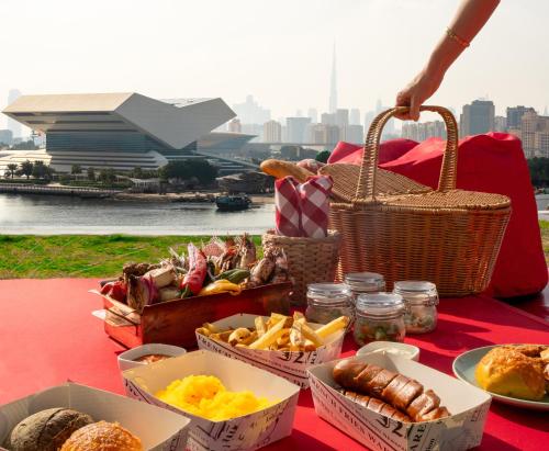 迪拜Crowne Plaza Dubai Festival City的一张桌子,上面有篮子食物,放在红色桌布上